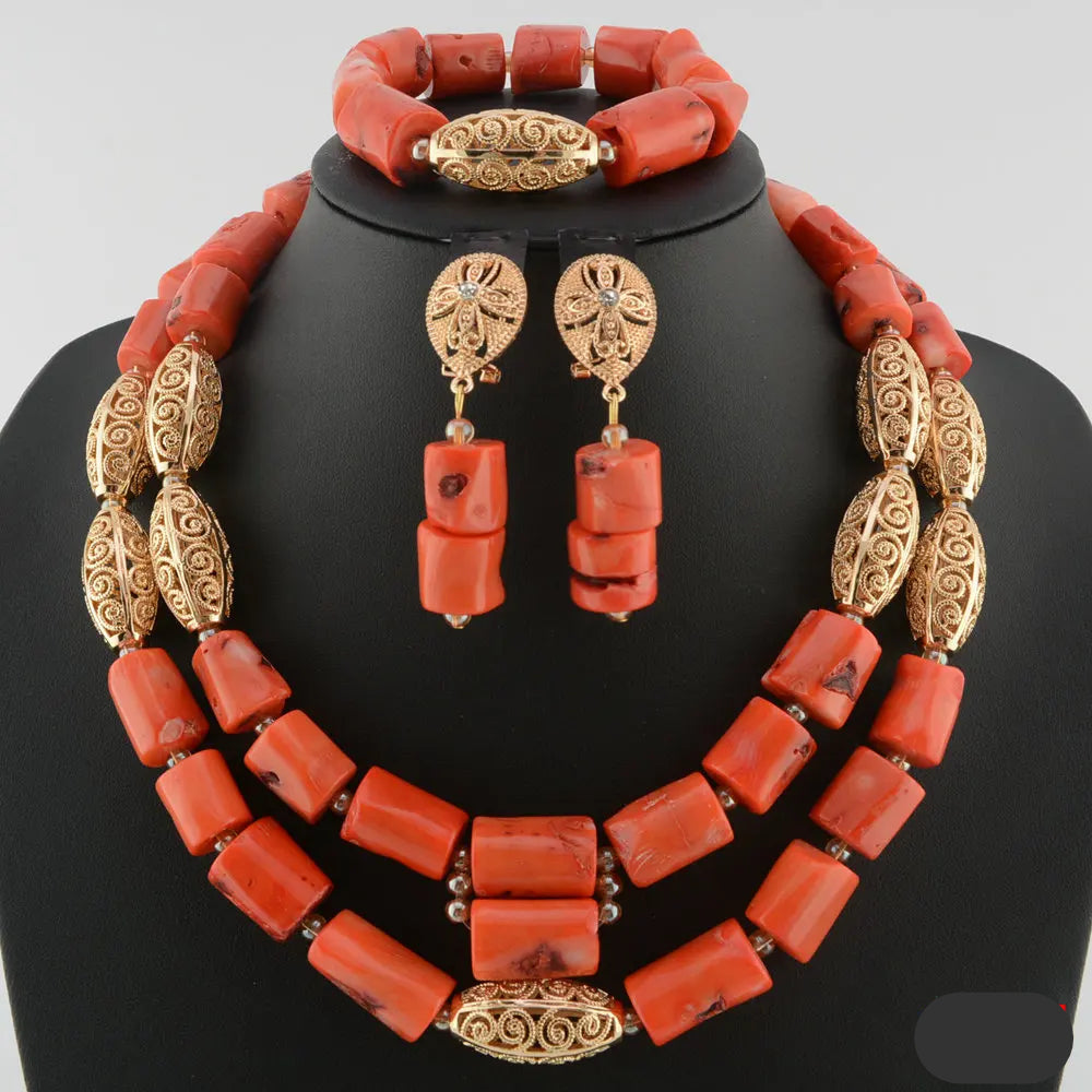 Coral jewelry set with gold accents on a black mannequin