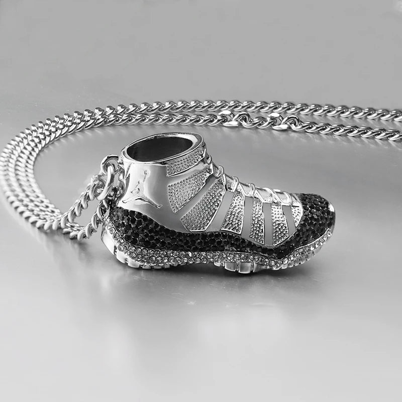 Silver sneaker pendant with chain on a light gray background